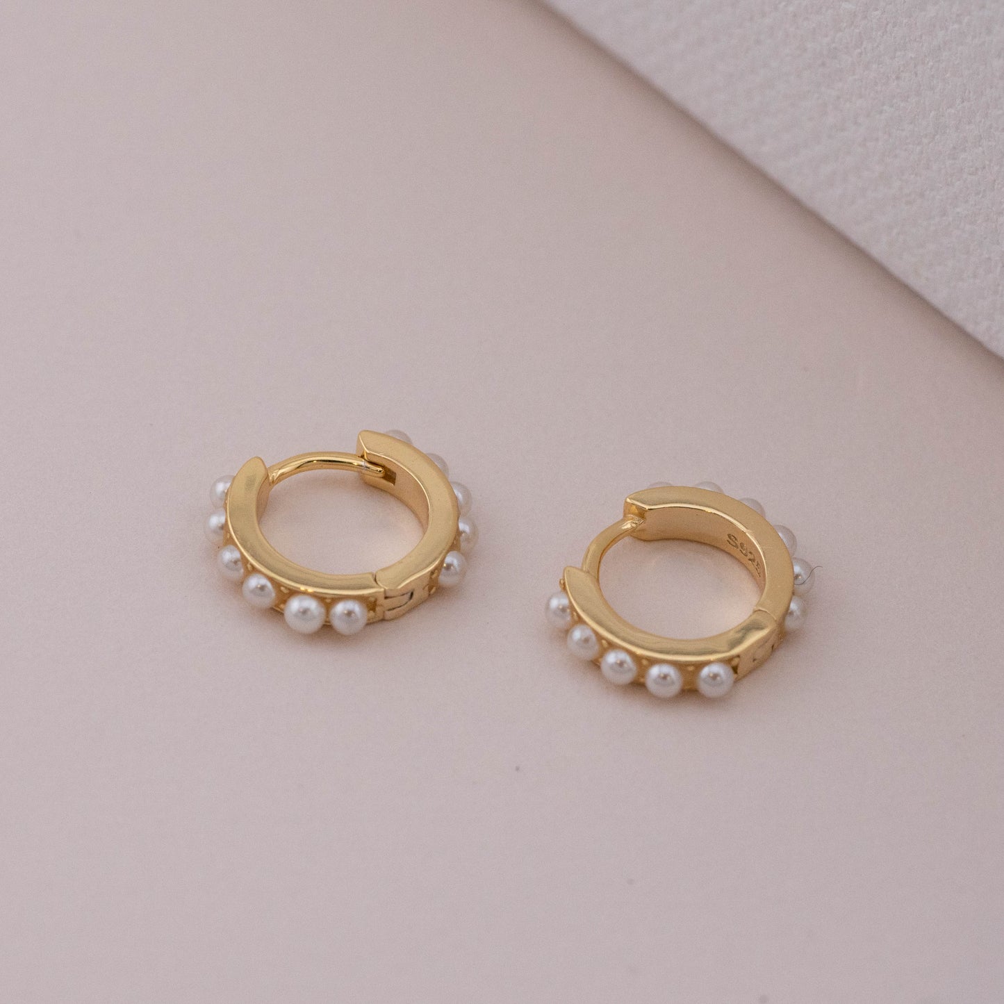Non-tarnish gold hoops with tiny pearls, laid down to show hinged closure