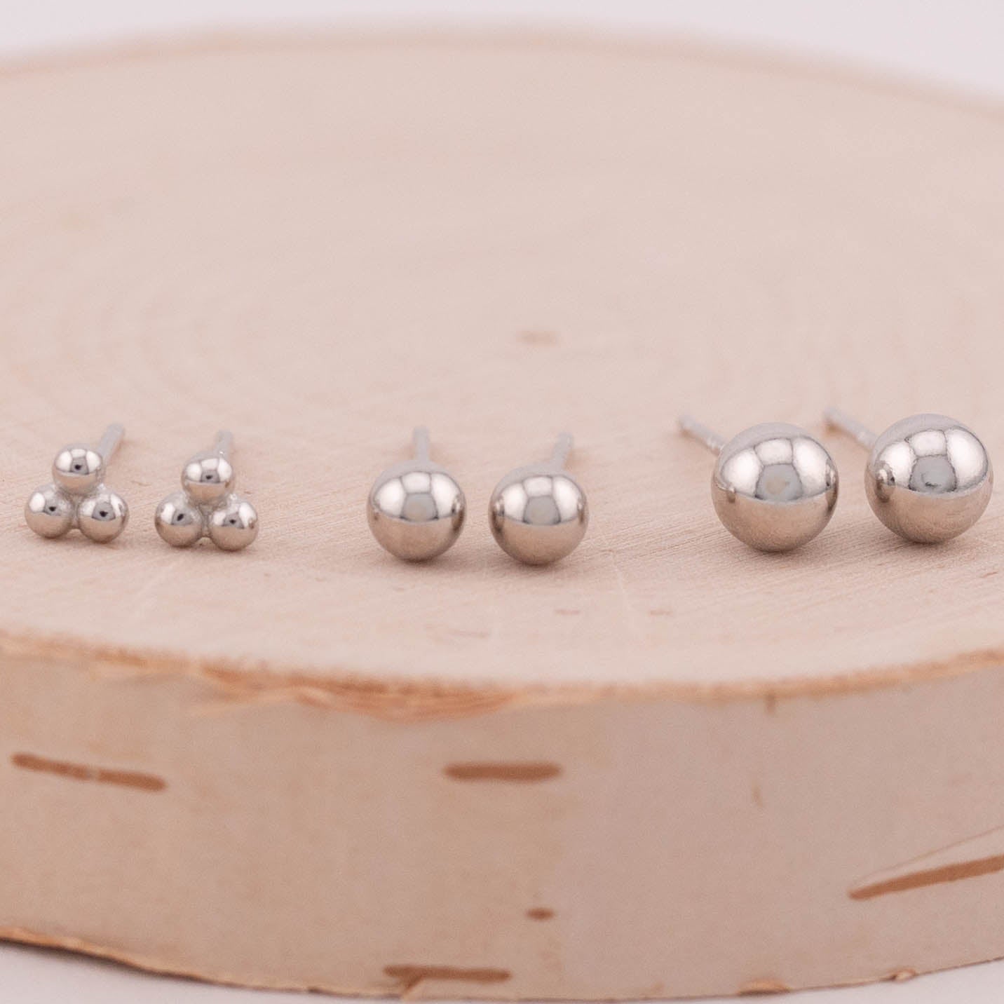 Image showing three sets of silver ball stud earrings of varying shapes and sizes, captured from the front to highlight their differences. Perfect for showcasing the versatility and style options available in silver ball stud earrings.