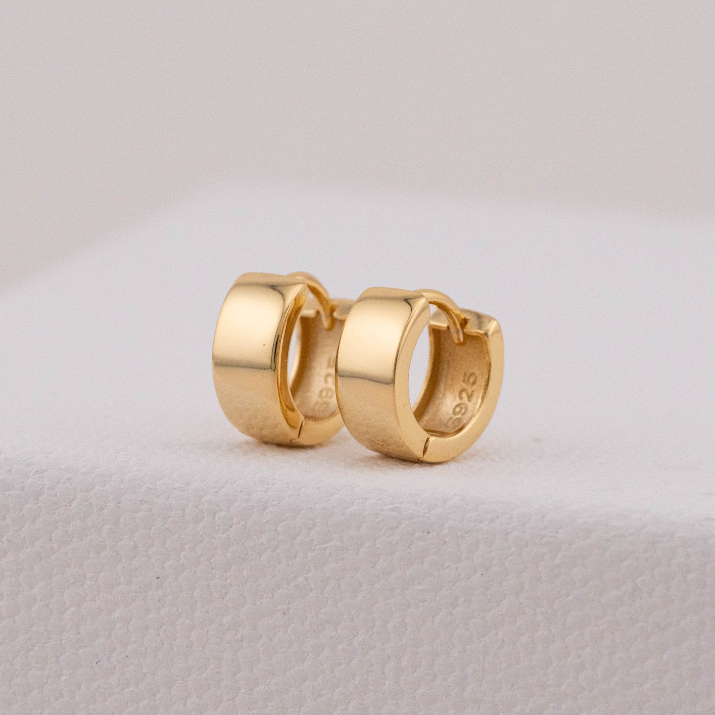 Close-up of tarnish-free earrings, showing detailed design and inner stamp.