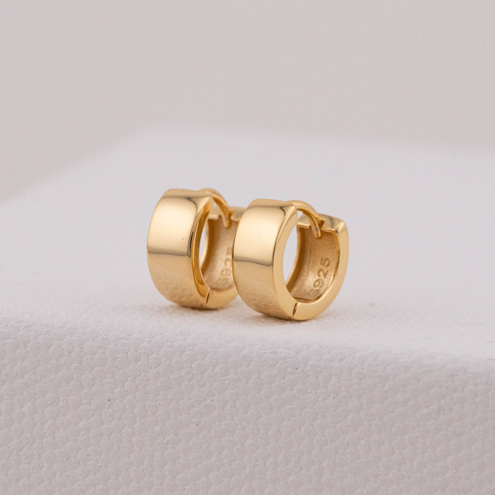 Close-up of tarnish-free earrings, showing detailed design and inner stamp.