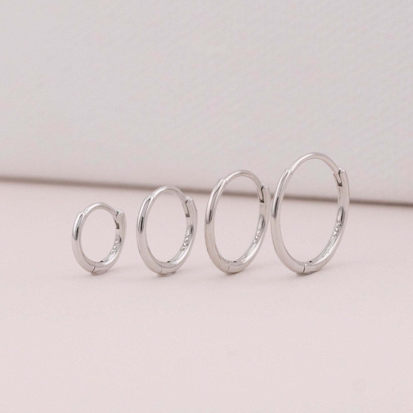 mini hoop earrings in different sizes are standing upright, showing it could be worn as stack sets