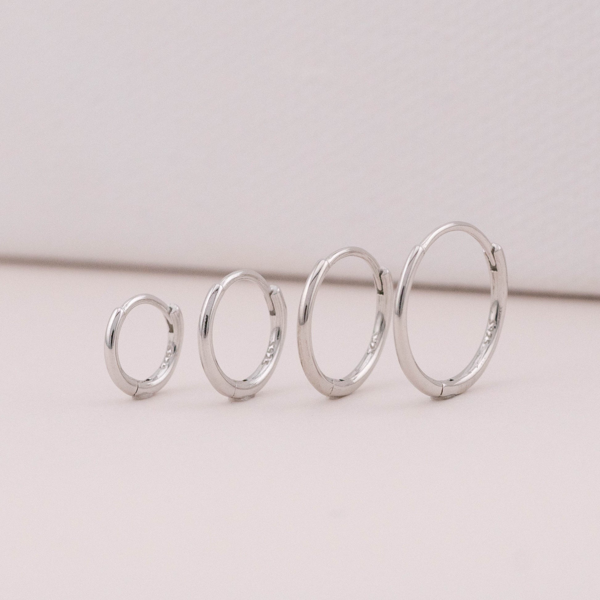 mini hoop earrings in different sizes are standing upright, showing it could be worn as stack sets