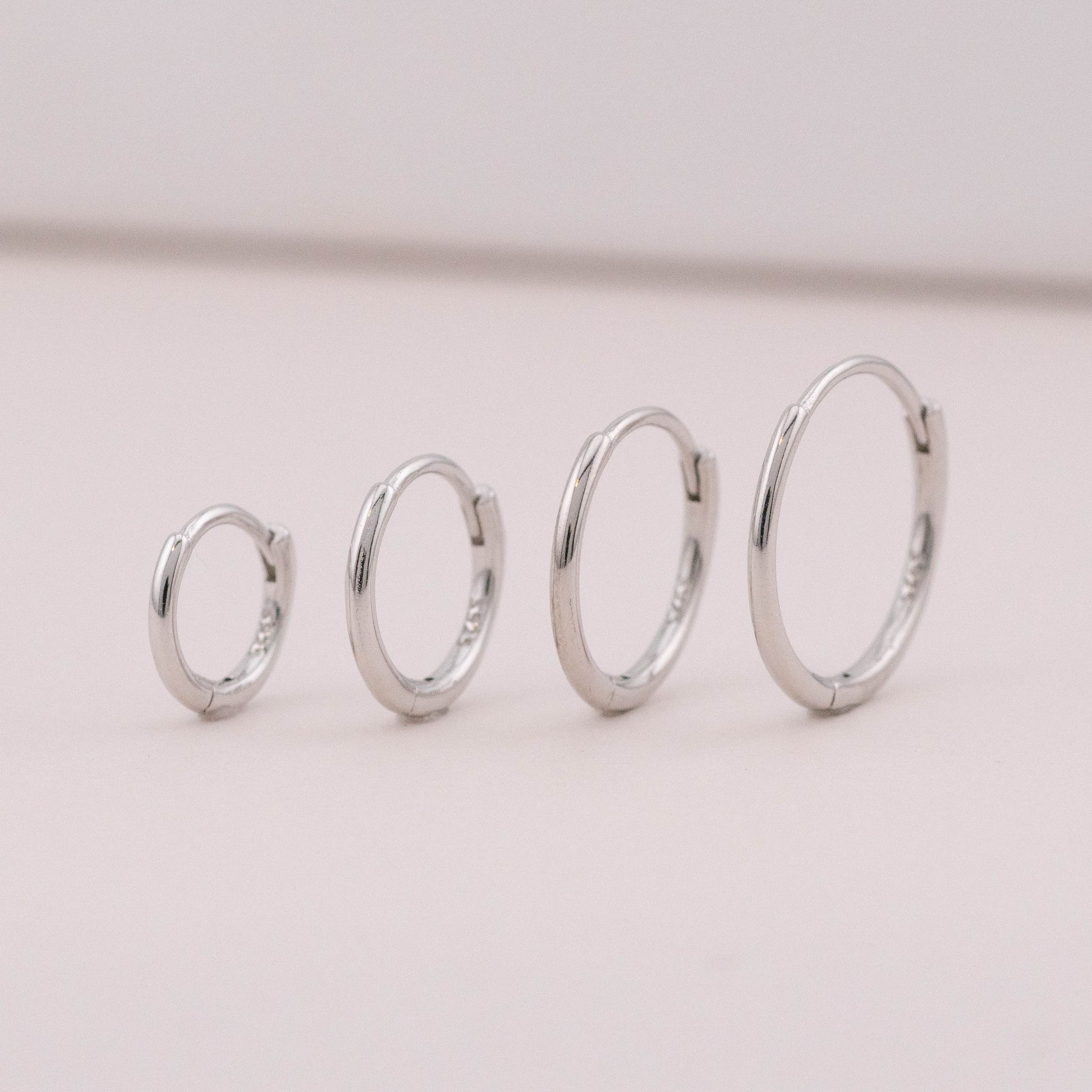 Sterling silver mini huggies side by side showing size differences, great for 3 holes and piercings.