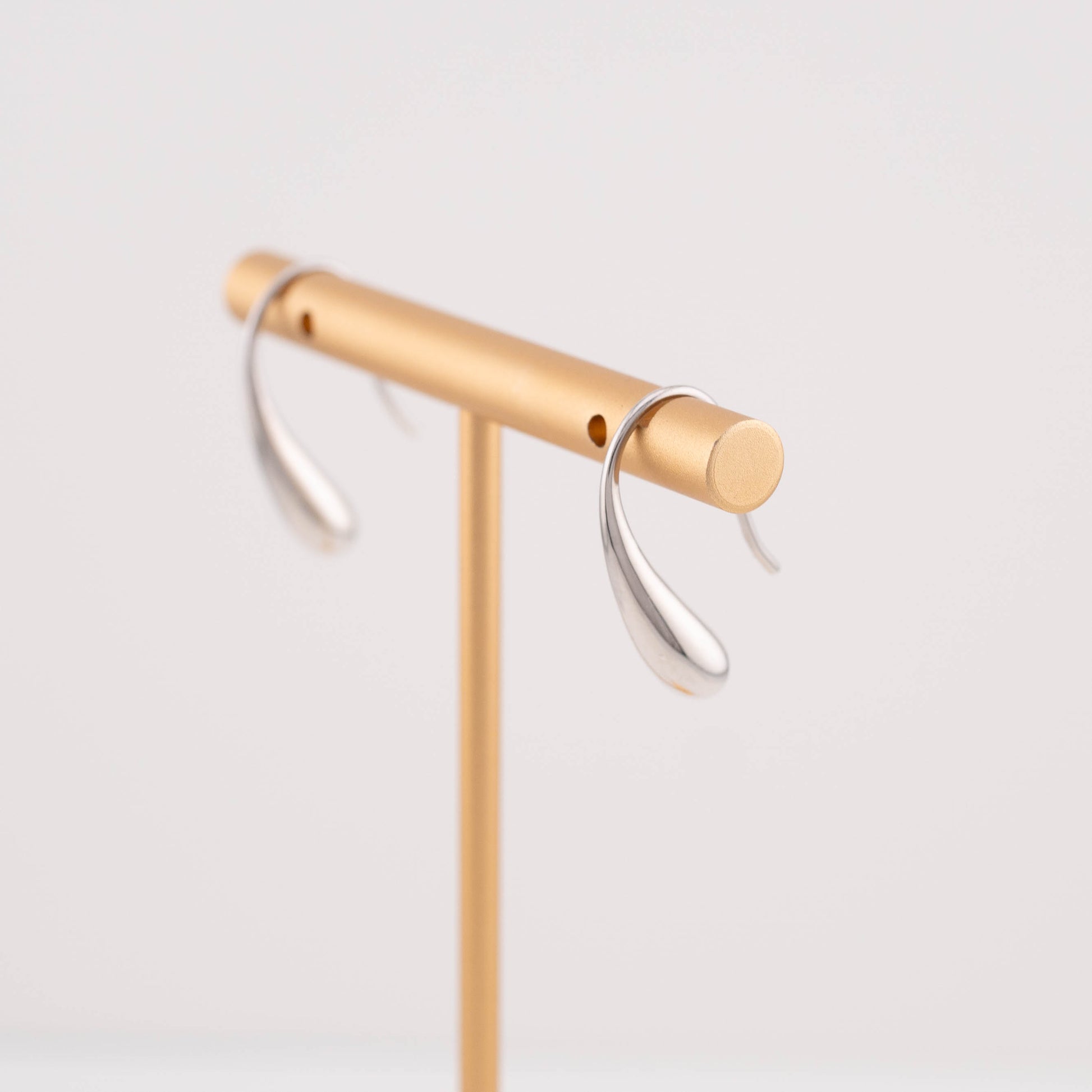 Everyday tear drop earrings displayed on an earring stand, demonstrating how they look when worn